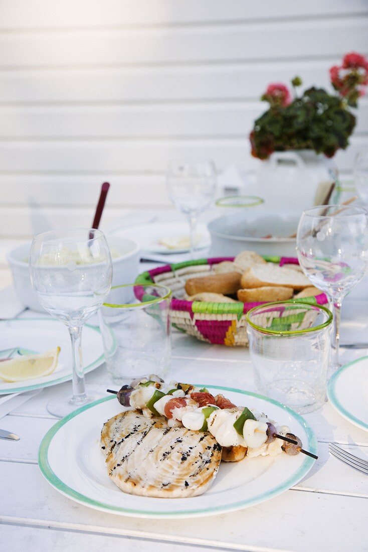 Mixed grill, bread and glasses on a table al fresco