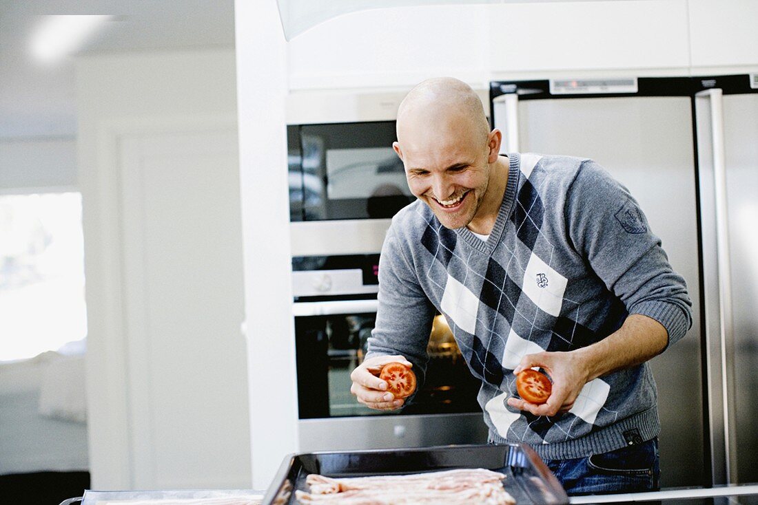A man laughing while cooking