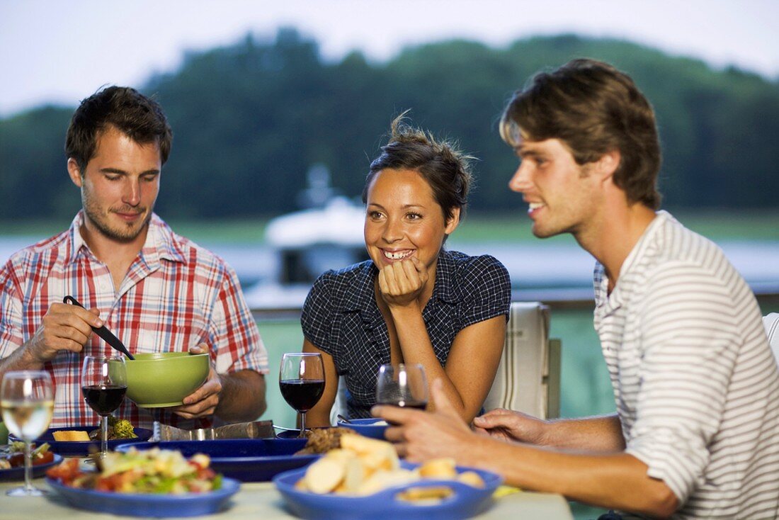 People eating barbecued food out of doors