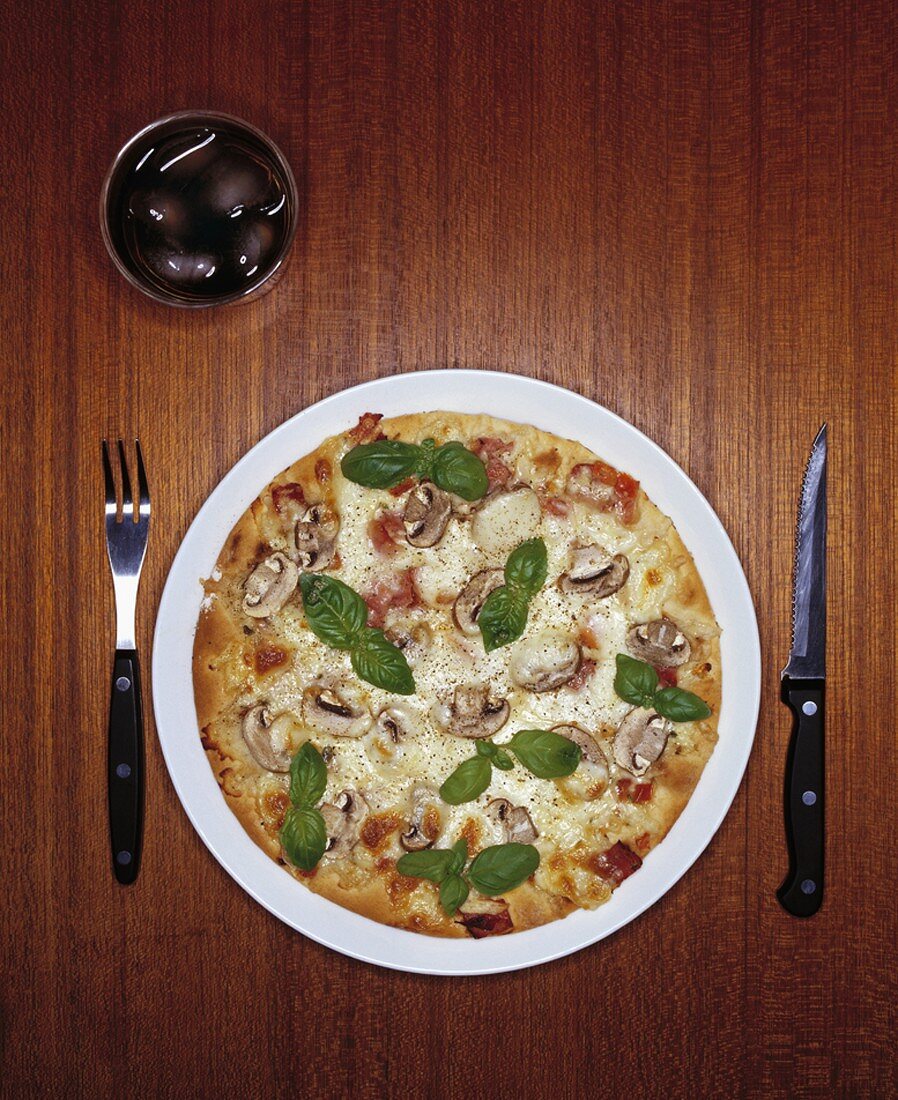 Pizza mit Champignons und Basilikum (Draufsicht)