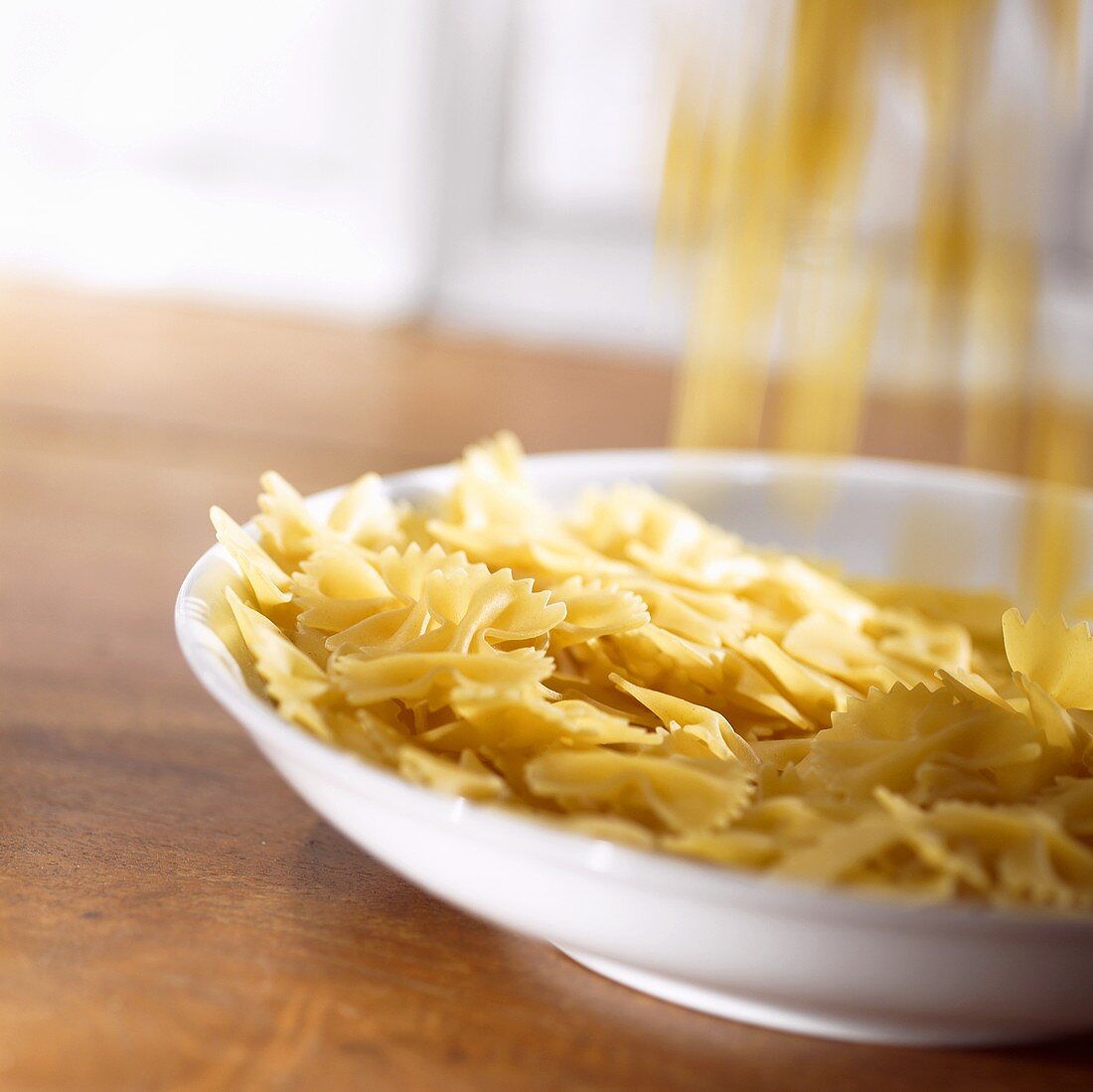 Farfalle falling onto a deep plate