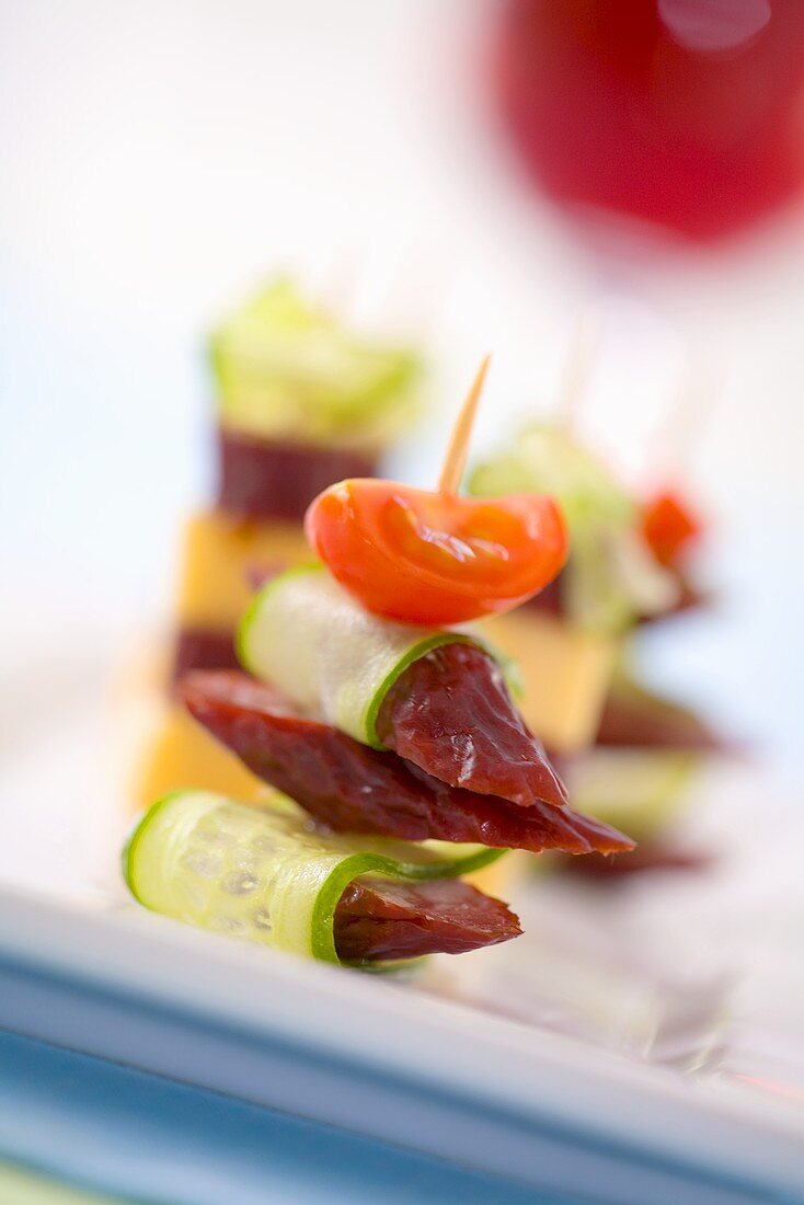 Sausage slices, cucumber and tomato on cocktail stick