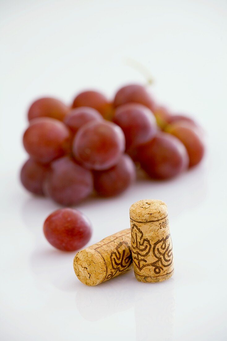 Two wine corks with red grapes