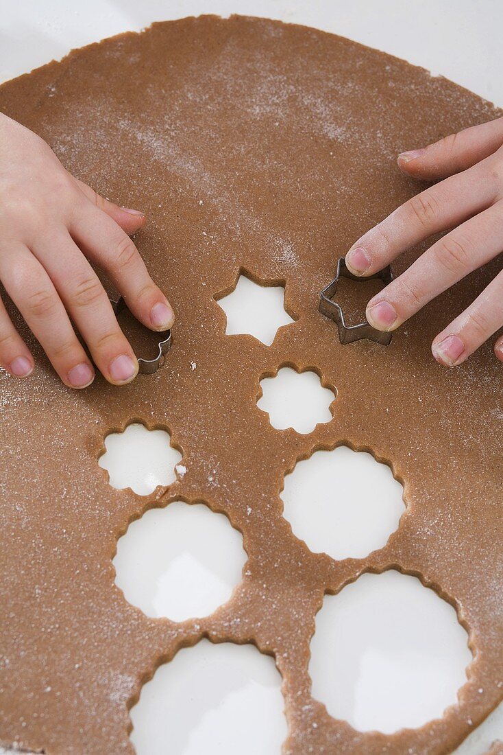 Kinder stechen Weihnachtsplätzchen aus