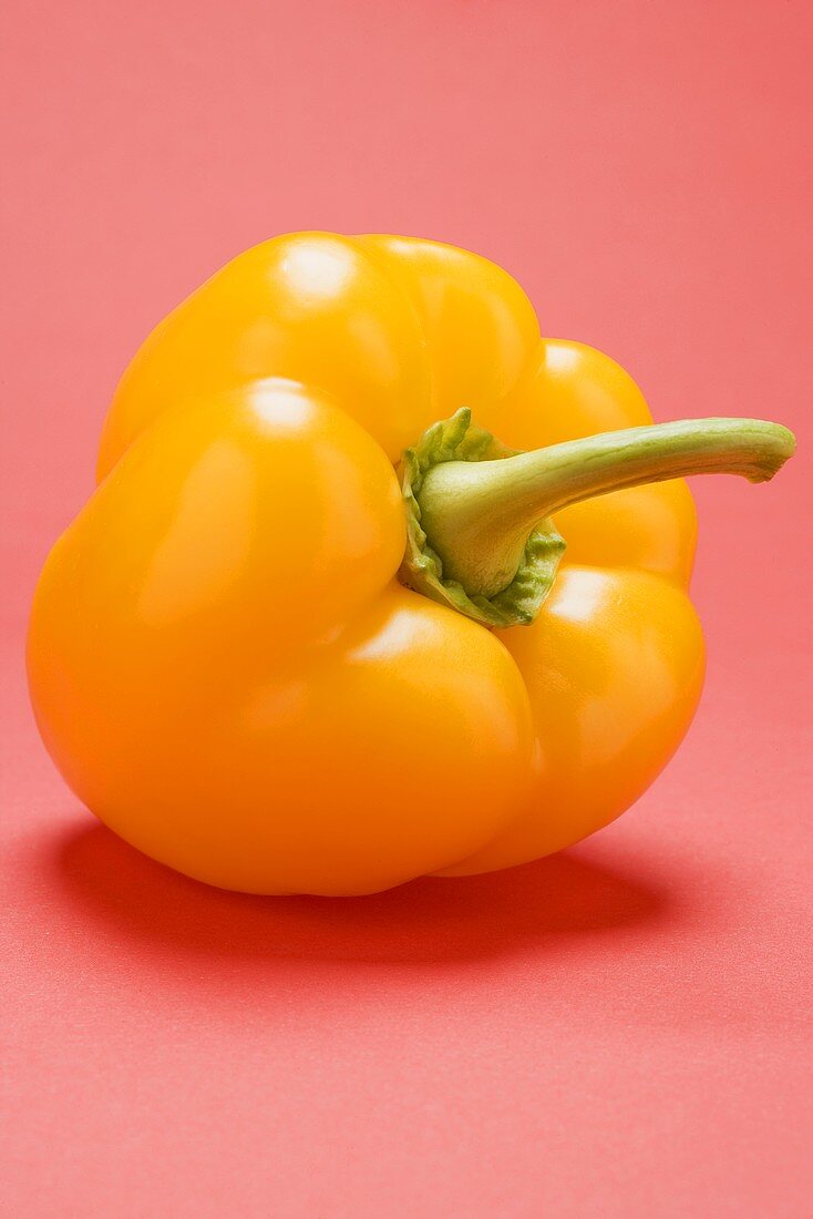 Yellow pepper on pink background