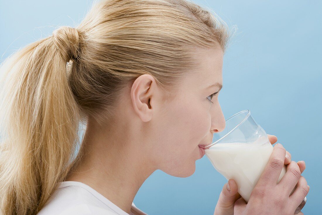 Young woman drinking a glass of milk