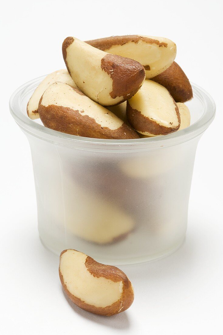 Several Brazil nuts in a glass