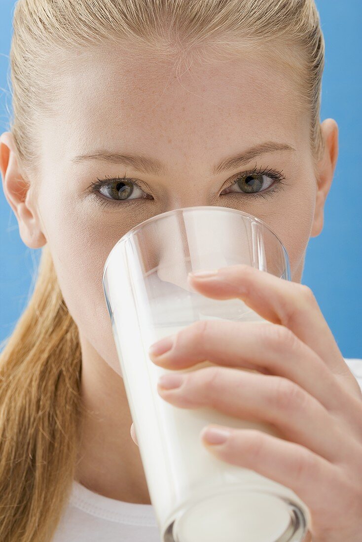 Young woman drinking a glass of milk