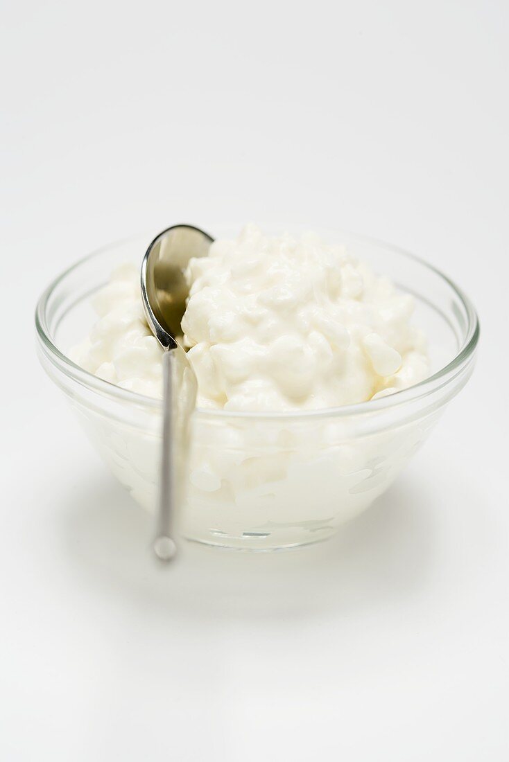 Cottage cheese in small glass bowl with spoon