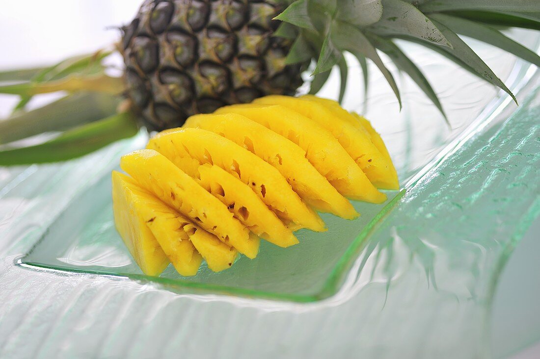 Baby pineapples, unpeeled and peeled and sliced