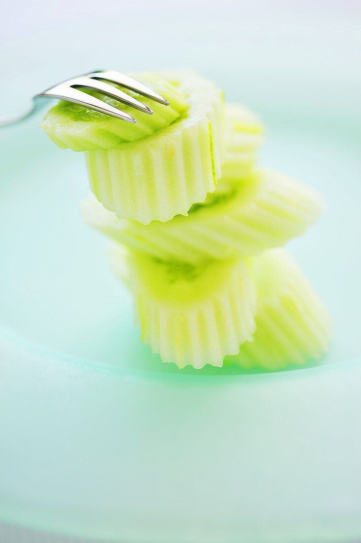 Peeled and sliced Thai cucumbers with fork