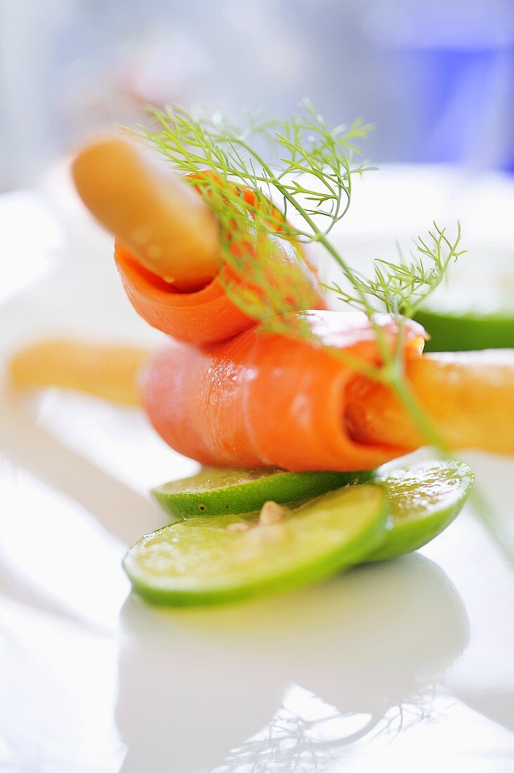 Smoked salmon wrapped around grissini with slices of lime