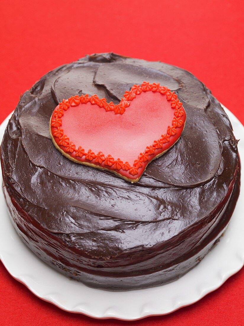 Chocolate cake with red heart-shaped biscuit