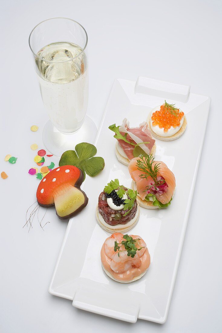 Canapés, glass of sparkling wine, good luck charms for New Year