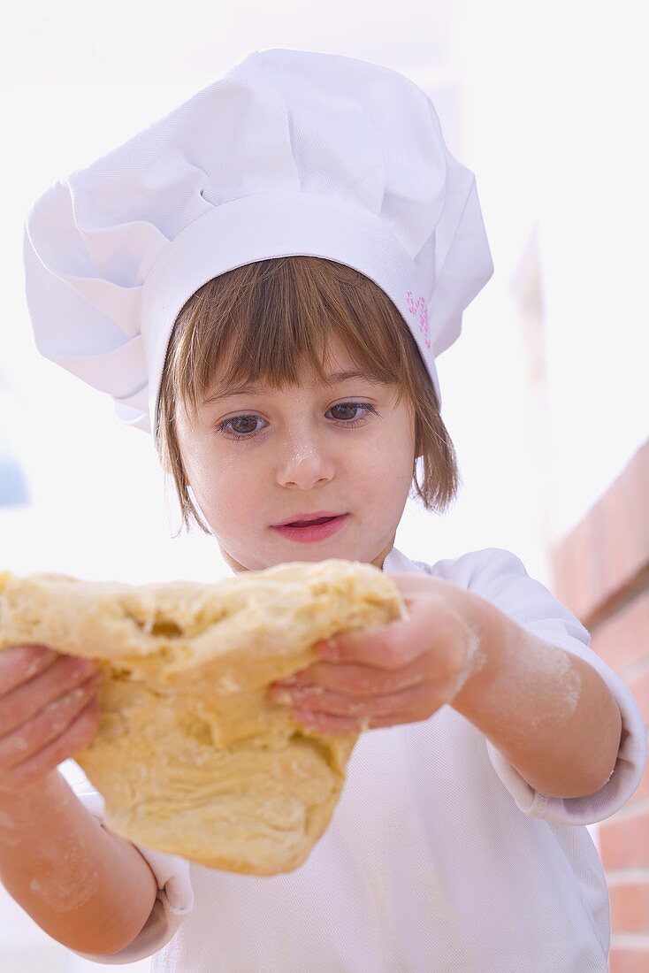 Girl in chef's hat handling pastry