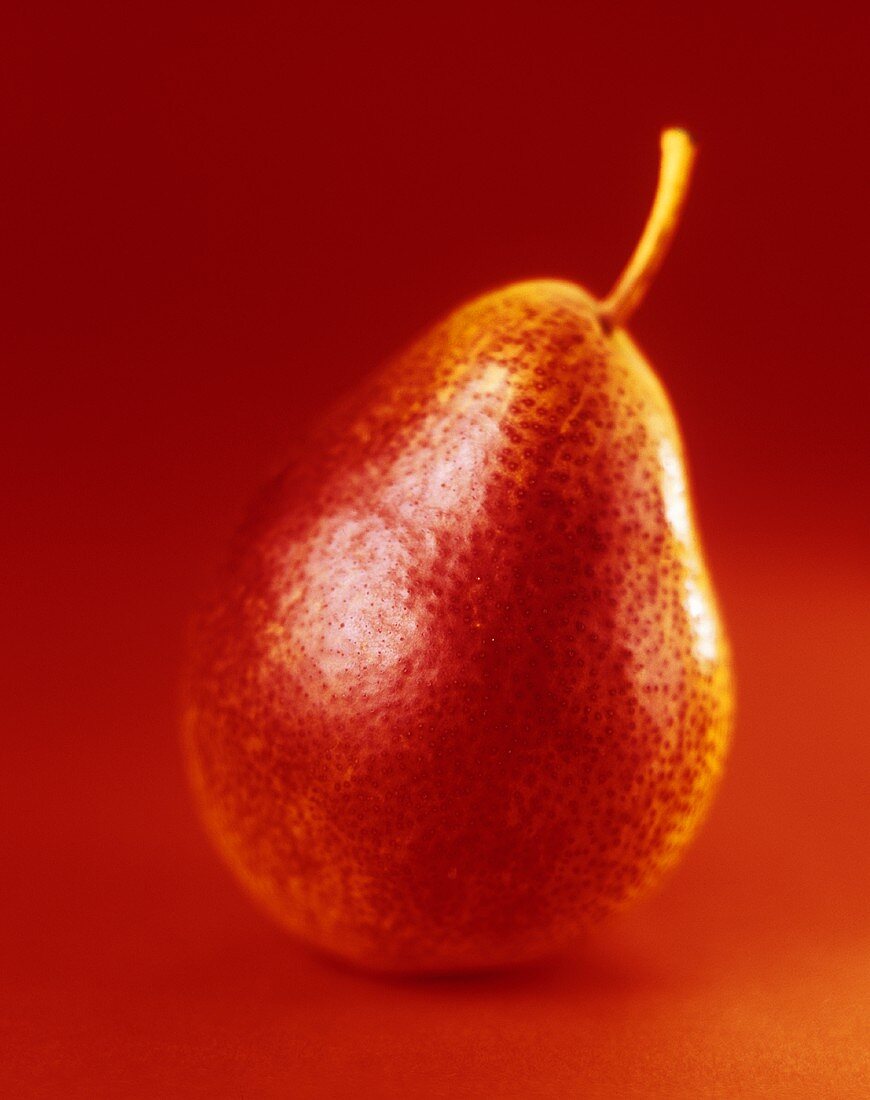 Eine Birne vor rotem Hintergrund