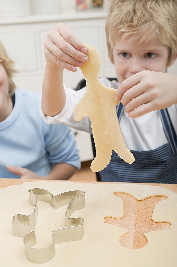 Two boys cutting out biscuits