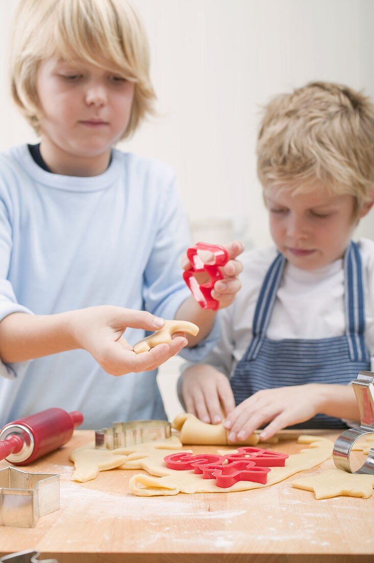 Two boys cutting out biscuits