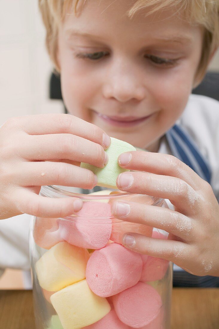 Junge nimmt Marshmallow aus Vorratsglas