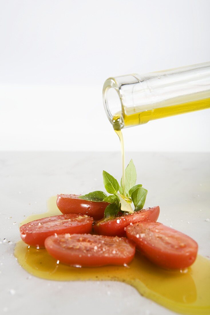 Pouring olive oil over tomatoes