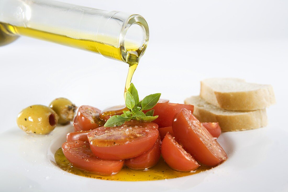 Pouring olive oil over tomatoes