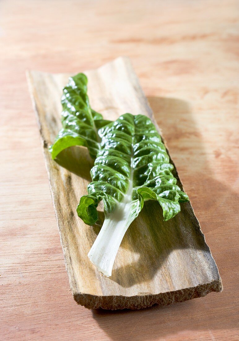 Chard leaves on piece of wood
