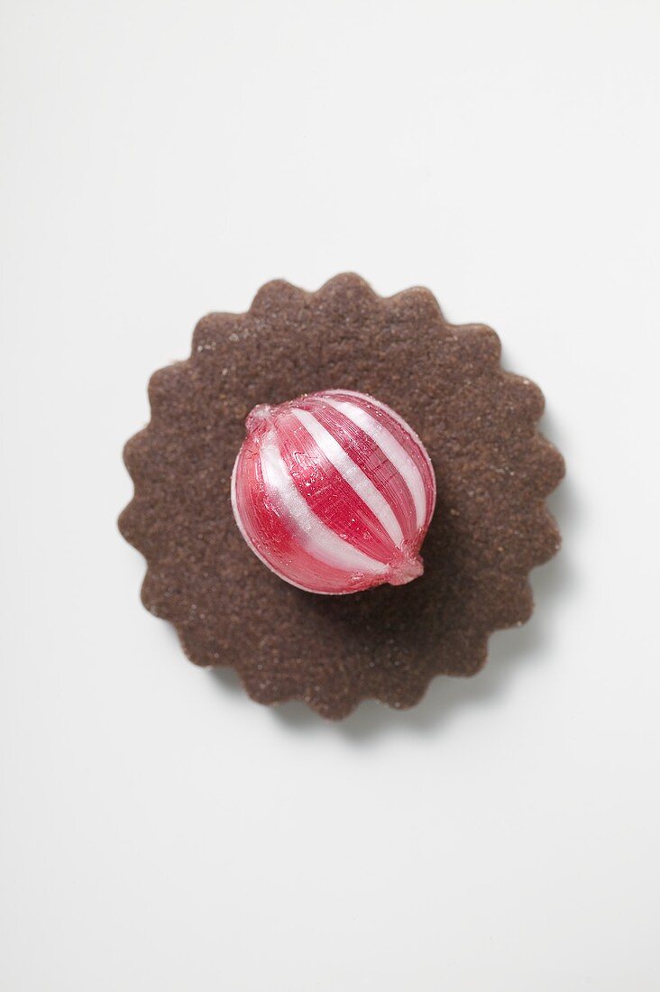 Schokoladenplätzchen mit rot-weißem Pfefferminzbonbon