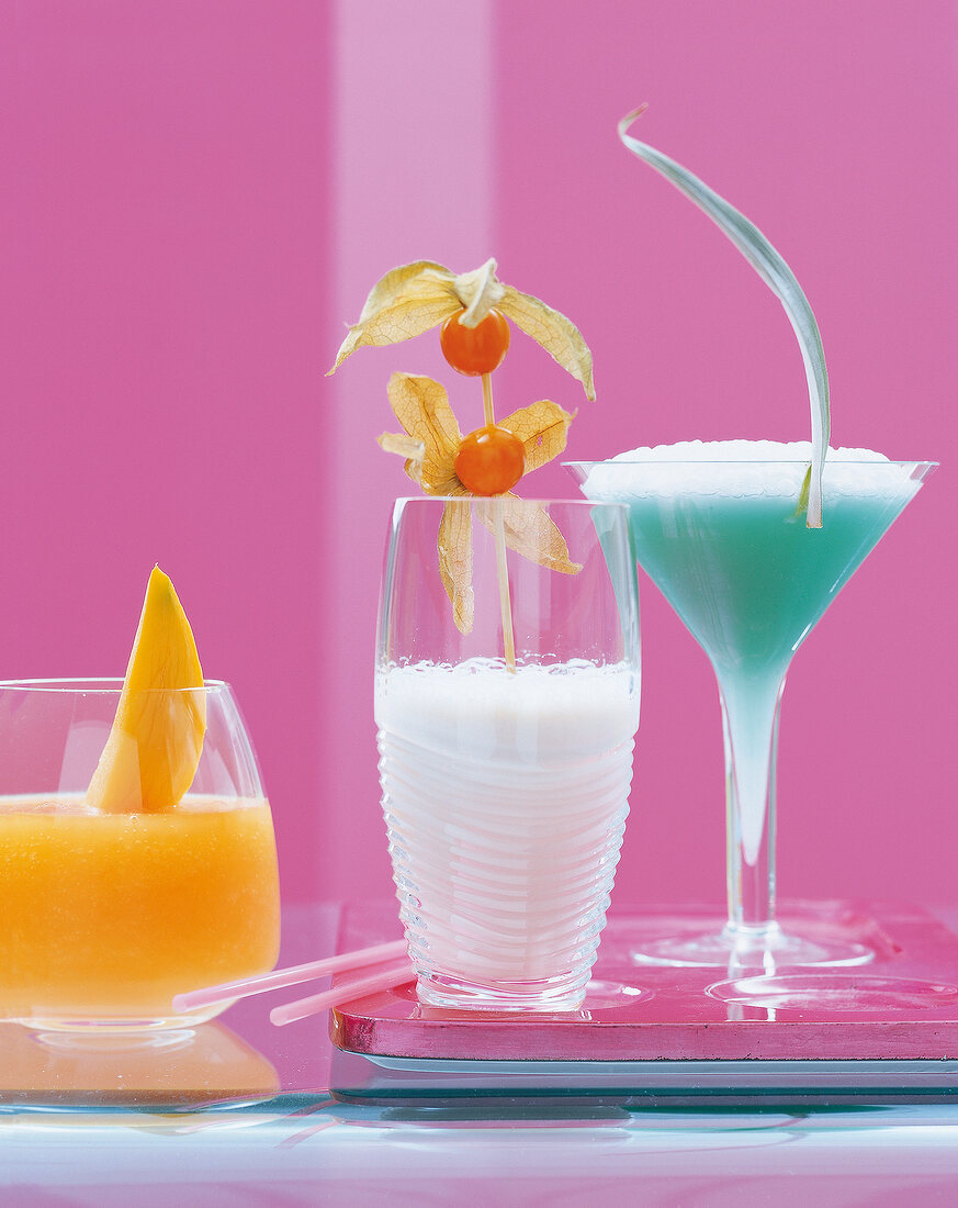 3 Cocktails vor pinkem Hintergrund: Beach Secret, Blue Lagoon u.a.