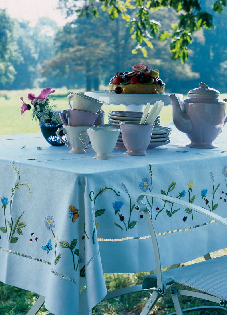 Breakfast table laid with food and crockery in lawn