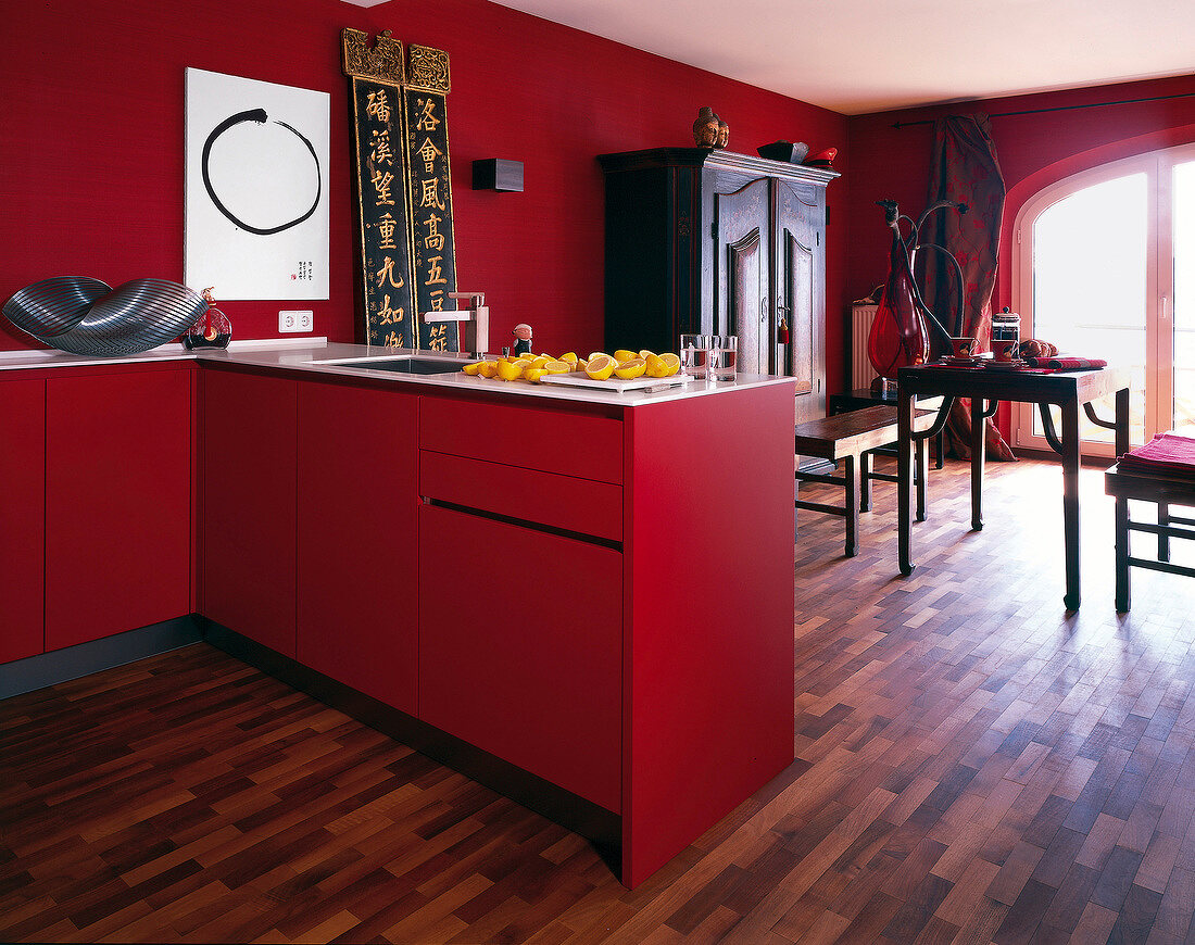 Red furnished kitchen with dark wooden parquet