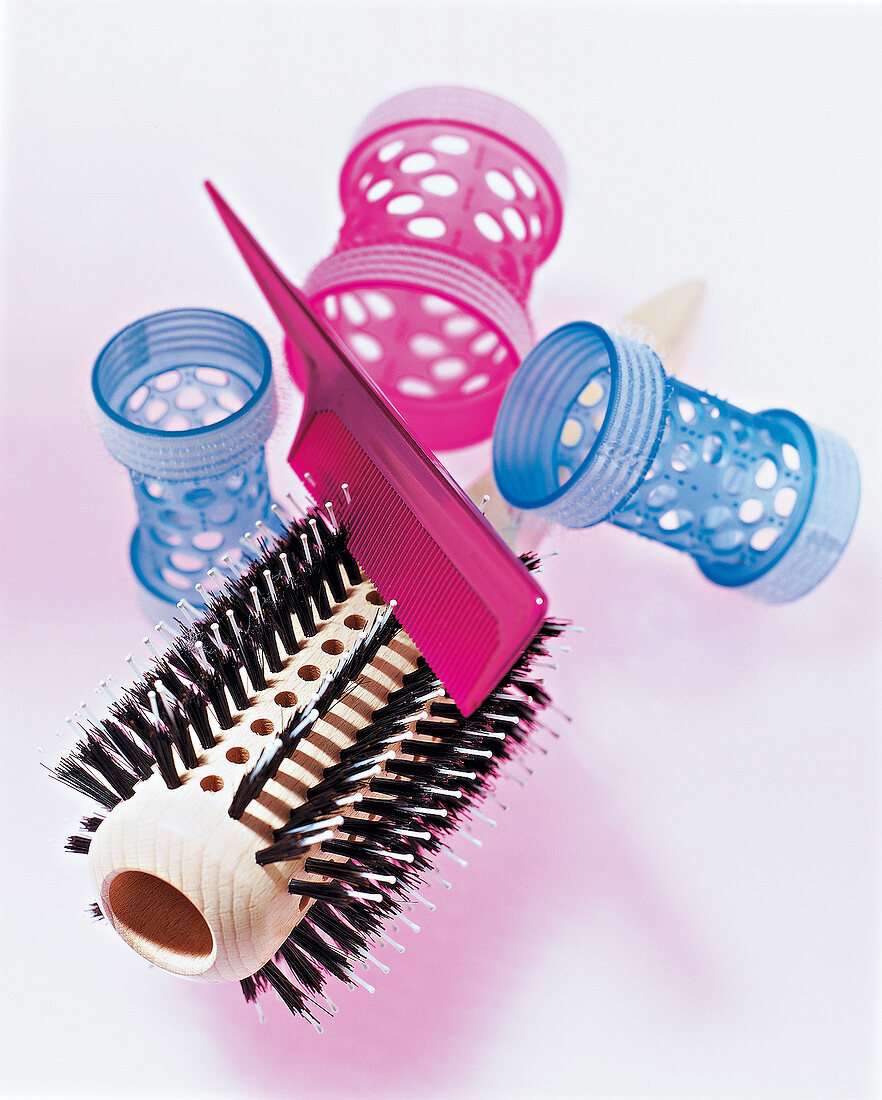 Haarbürste und Toupierkamm auf rosa Untergrund, Detail