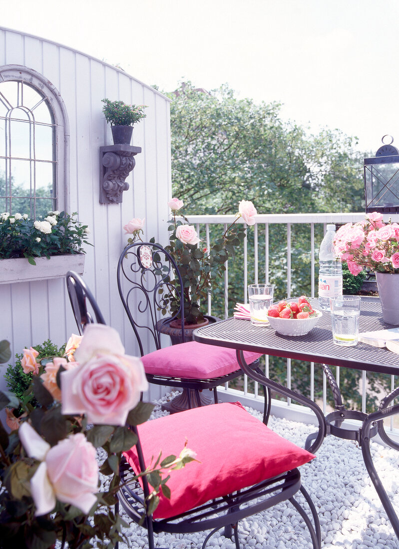 Mediterranean style balcony with table and chairs decorated with flower vase