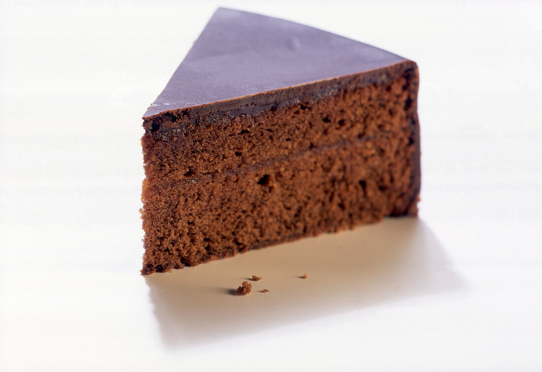 Close-up of piece of sachertorte on white background