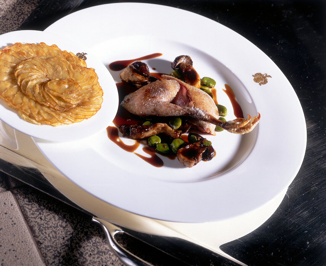 Bresse pigeon in salt crust with potato gratin on plate