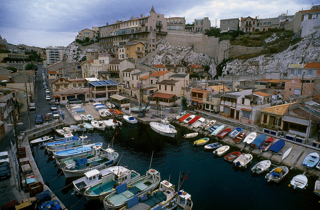Elevated view of small port with moored fishing boats in Marseille, France