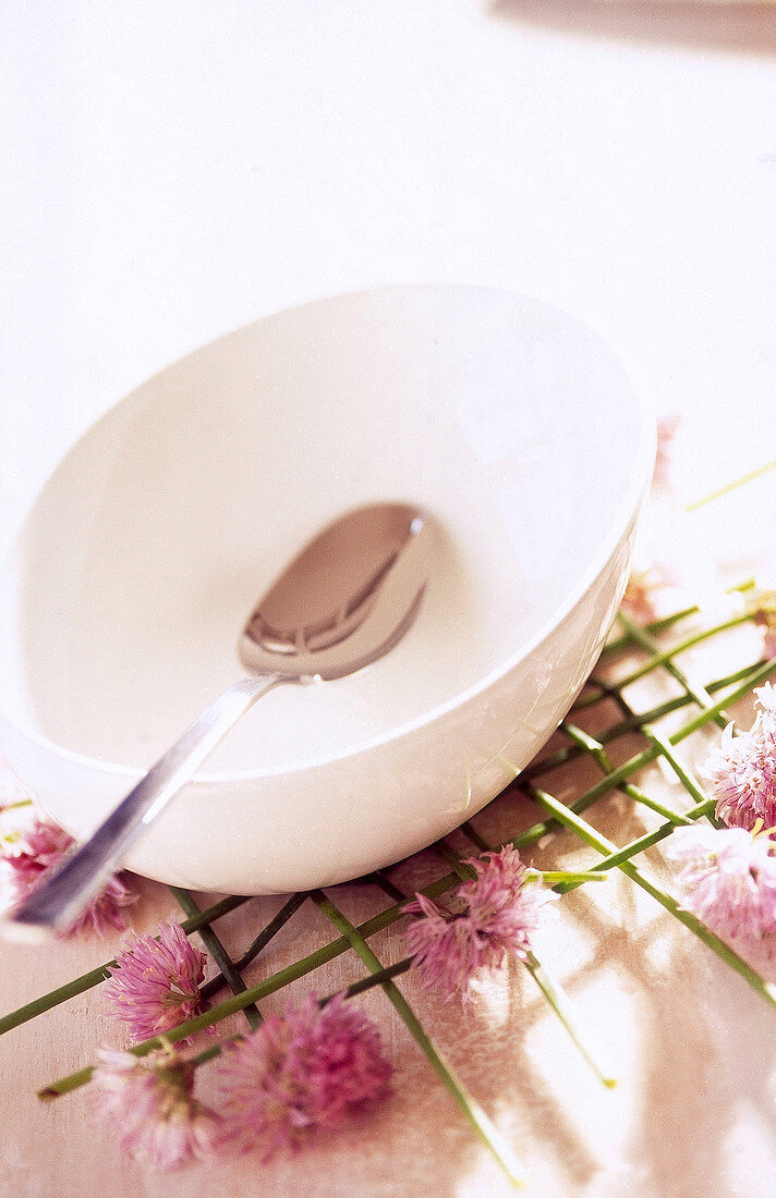 Close-up of white bowl and spoon decorated with chives