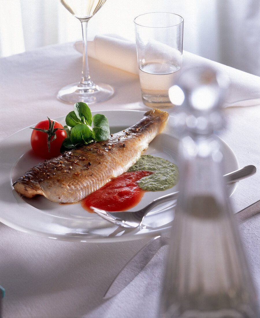 Fried char with tomato and corn salad cream on plate