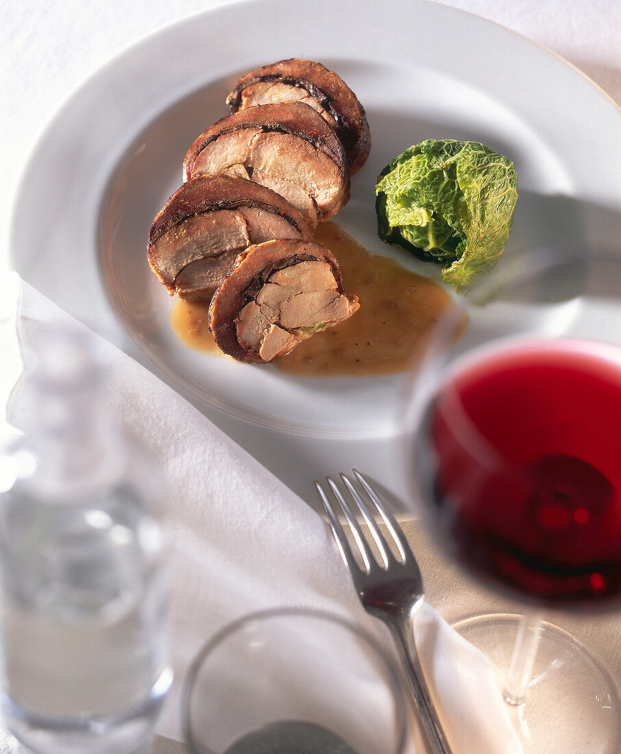 Crepinette of pheasant with truffles and savoy cabbage balls on plate