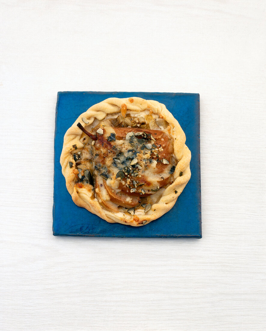 Hand pizza with pears and cream cheese on plate