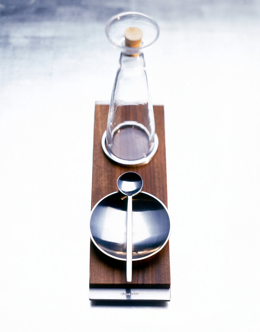 Glass carafe and bowl with spoon on walnut wooden tray
