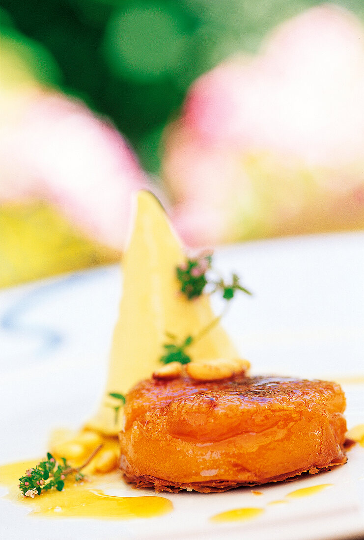 Close-up of tarte tatin with apricots, honey parfait and thyme flowers