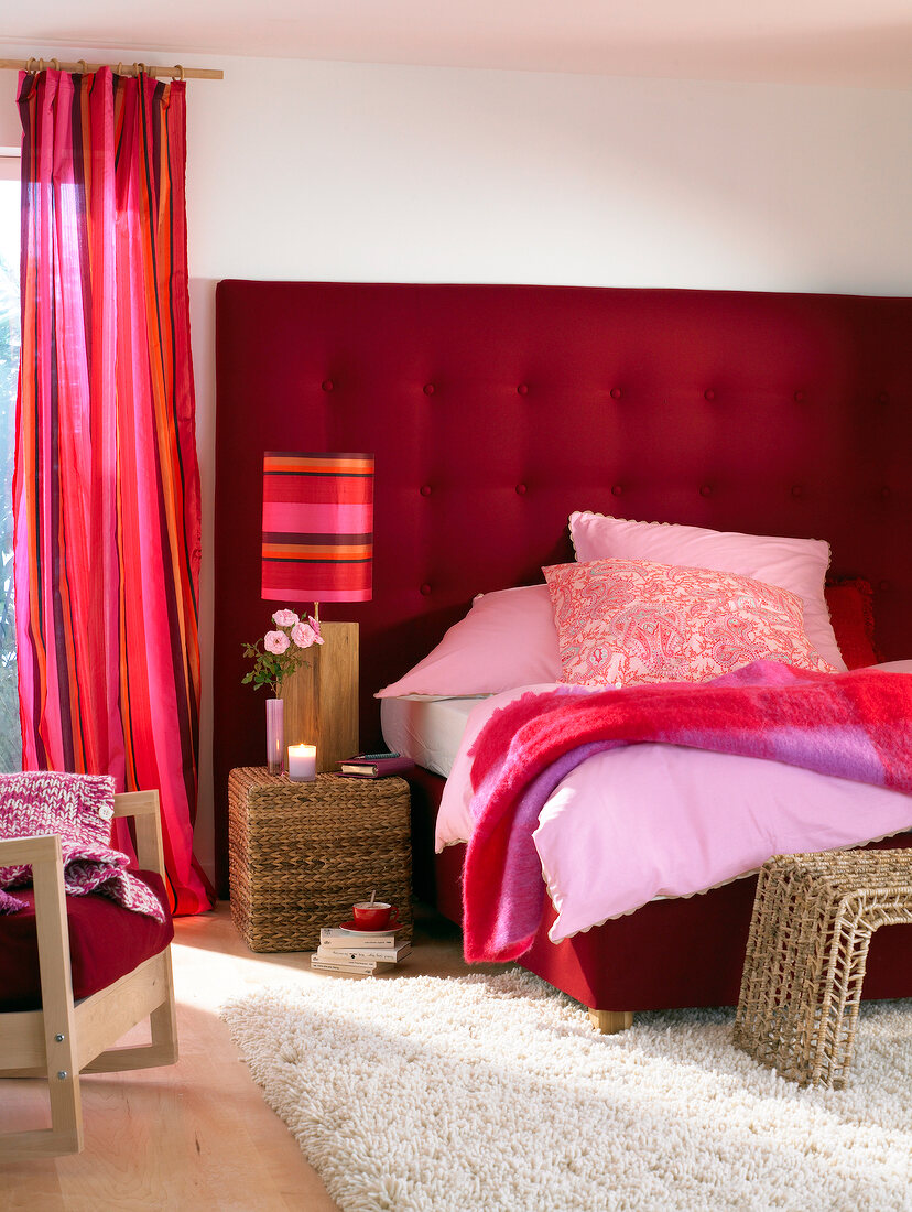 Bedroom with bed, cushion, curtain and lamp in shades of red