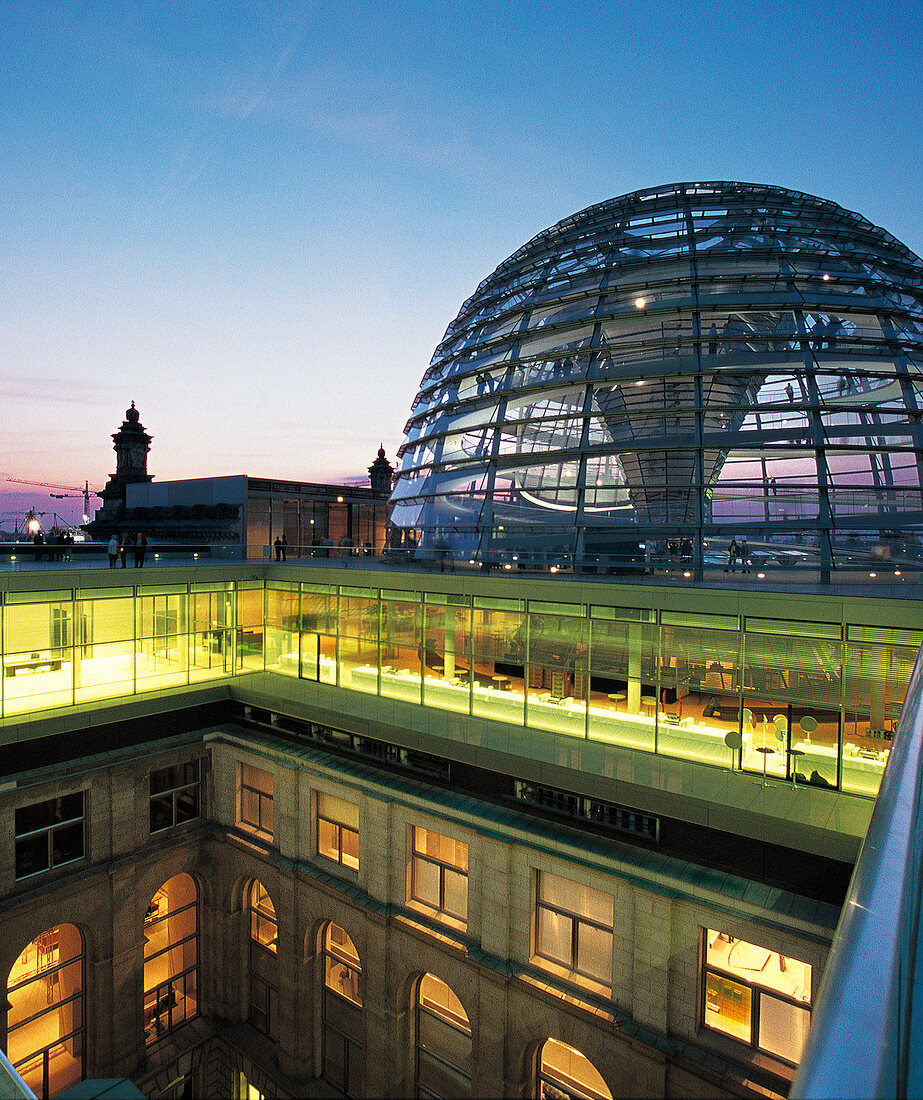 Die Kuppel des Reichstags in Berlin, beleuchtet in der Abenddämmerung