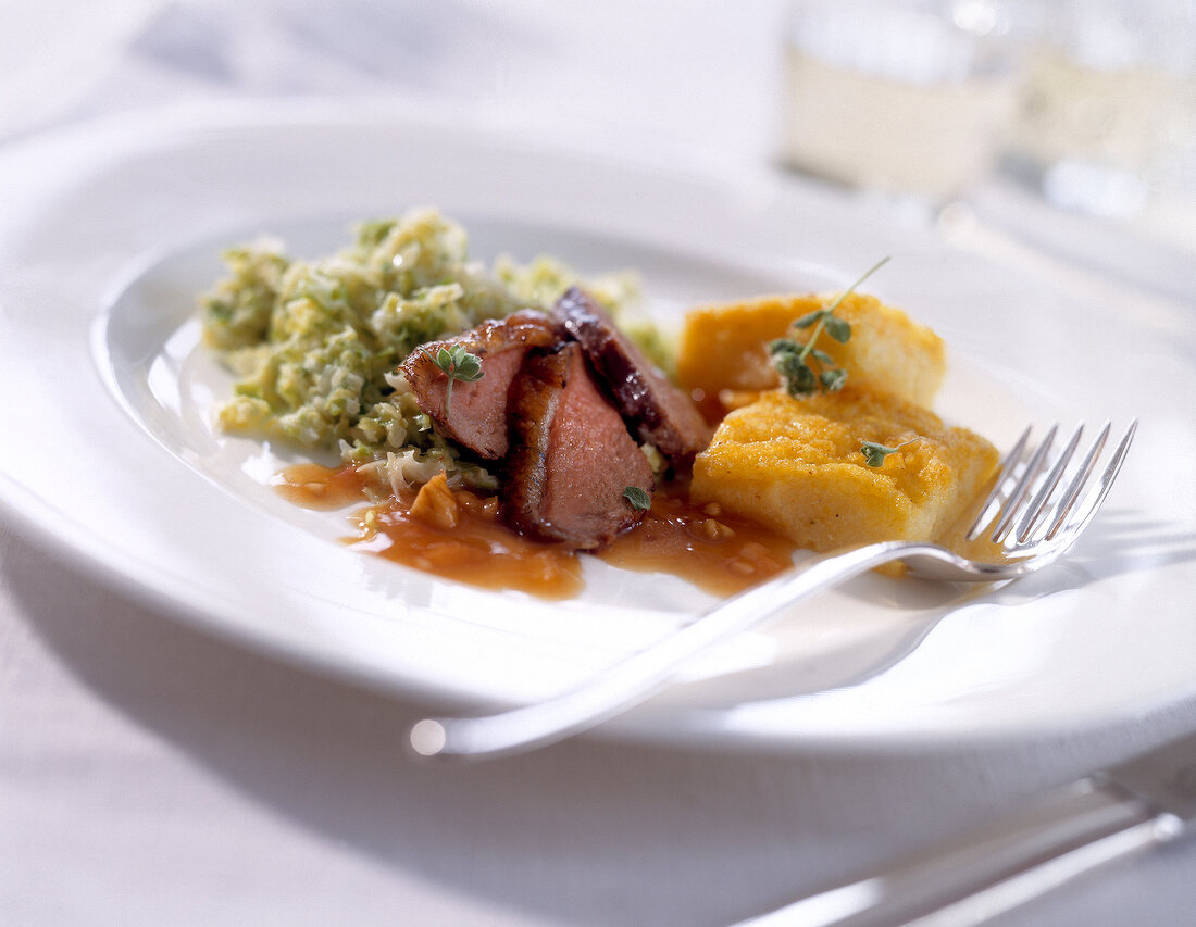 Close-up of wild duck breast with walnut quince sauce and polenta