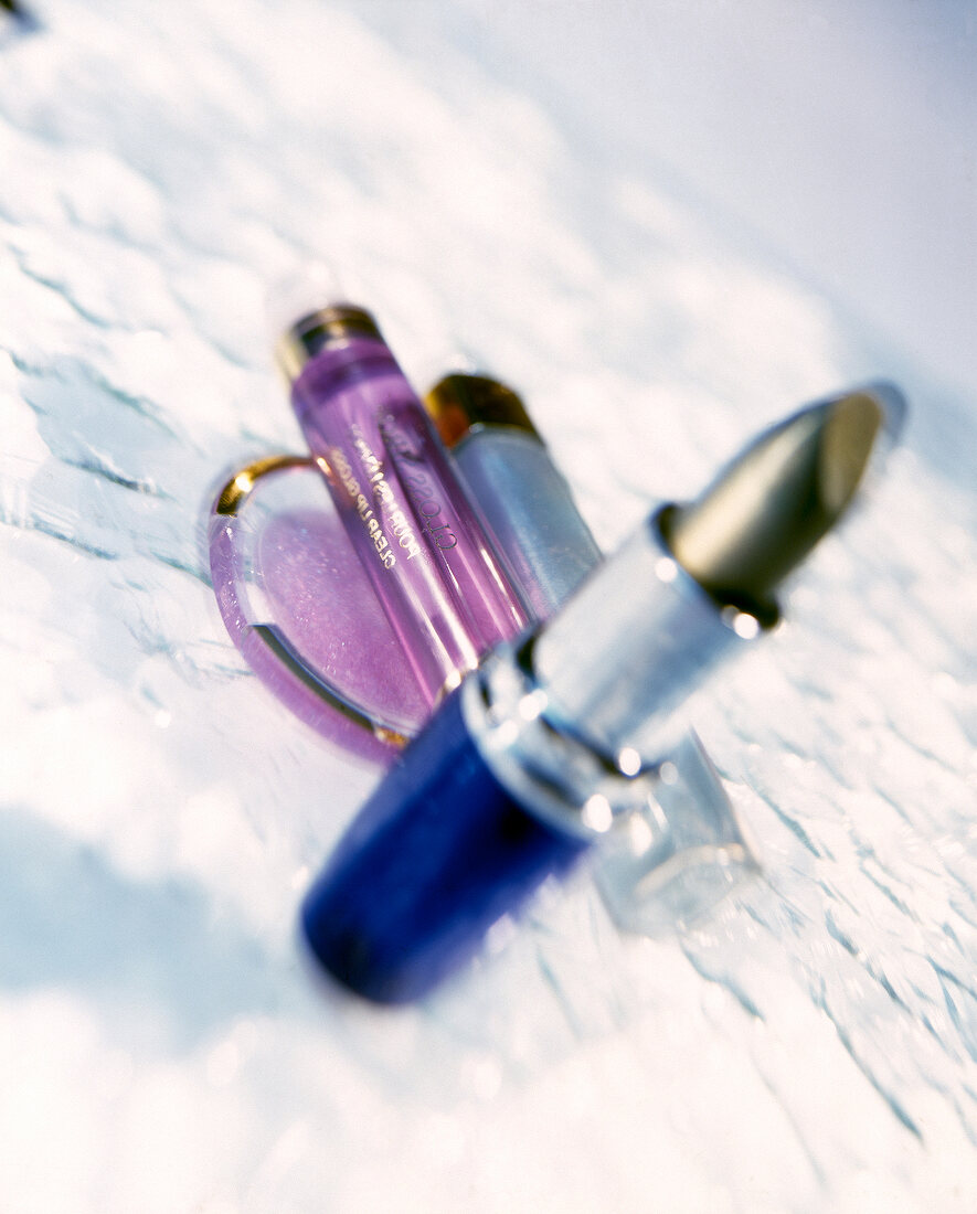 Close-up of various lipsticks in silver blue and pink shell kept on floor