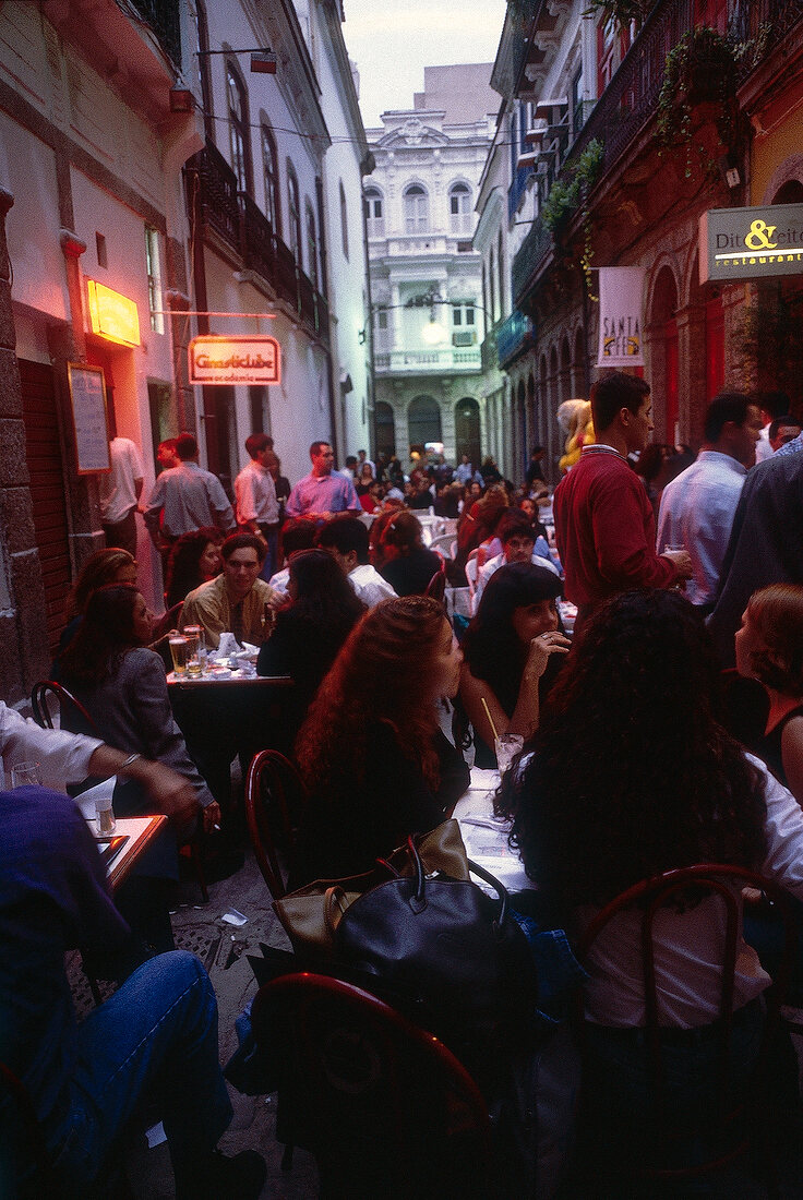 People sitting in cafe in city centre of Rio de Janeiro at dusk, Brazil