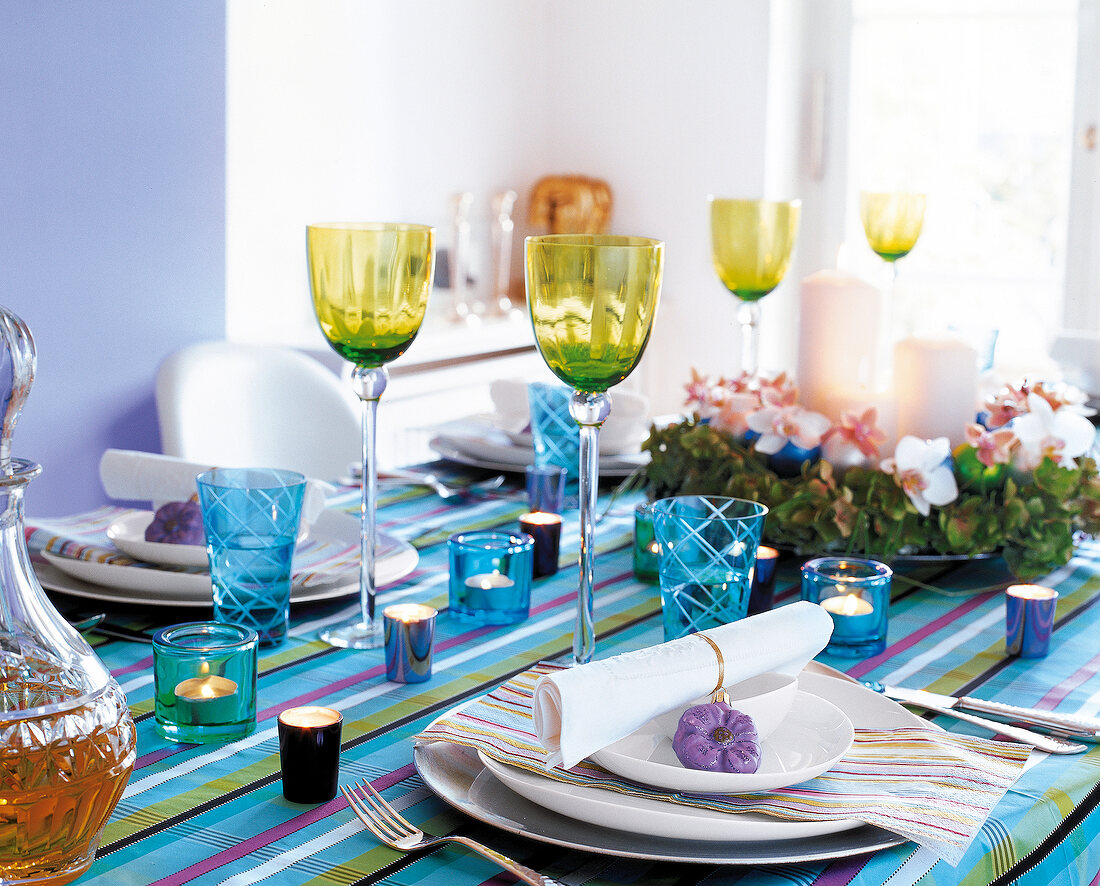 Table laid festively with striped cloth and lanterns