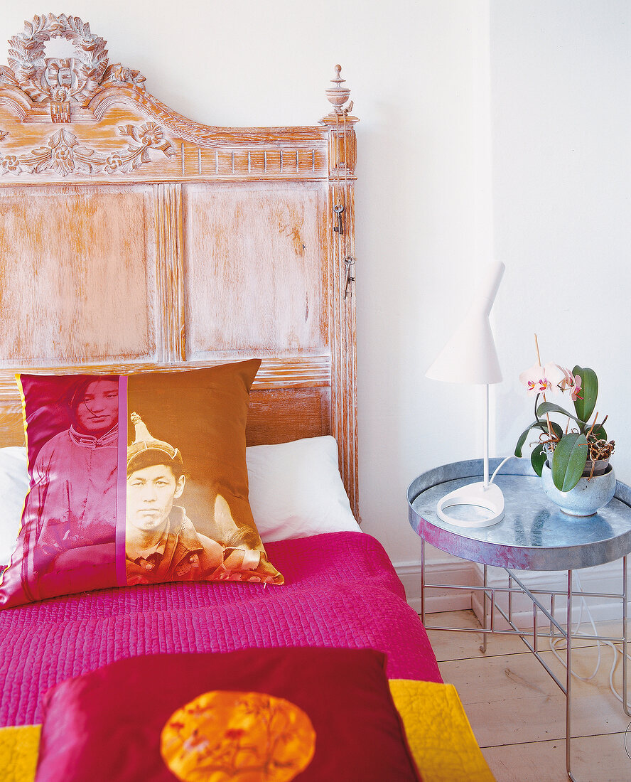 Antique bed with silk pillows and side table with lamp