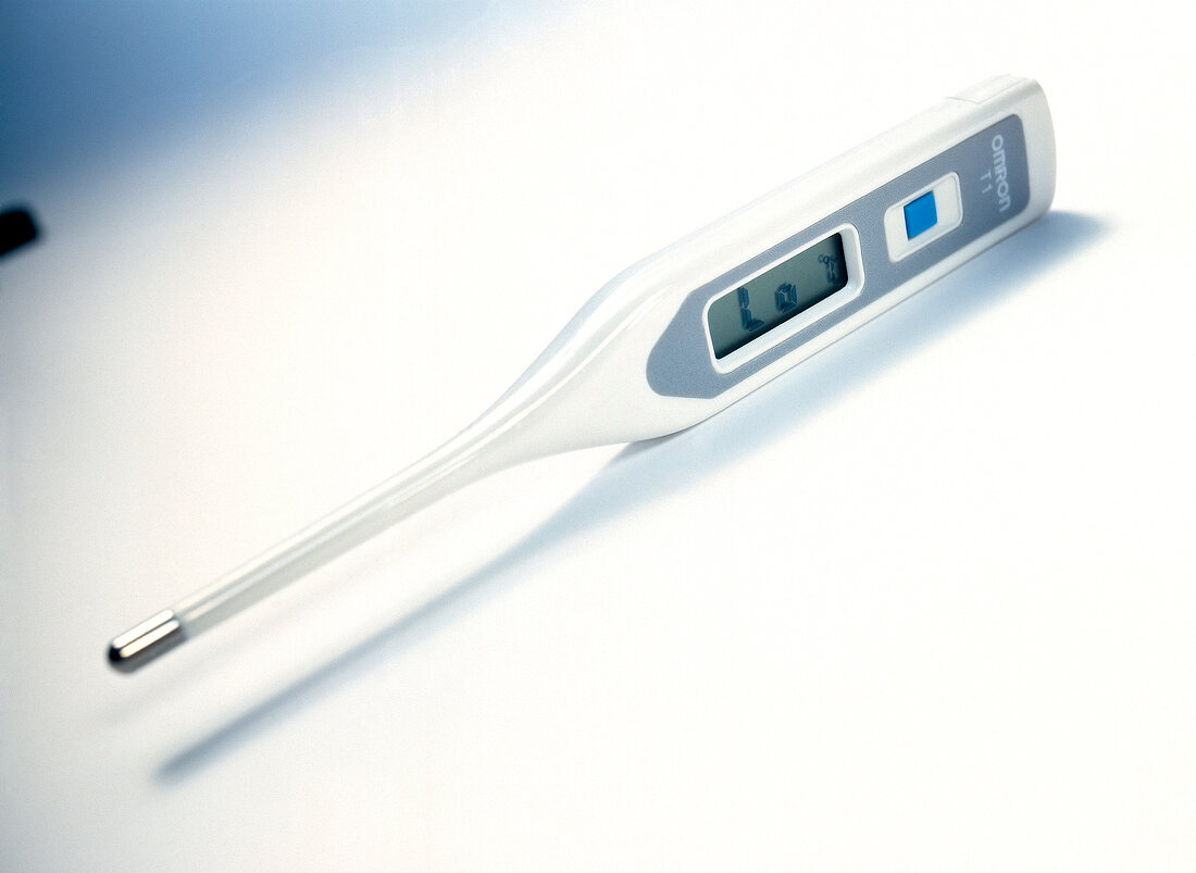 Close-up of digital thermometer placed on white background