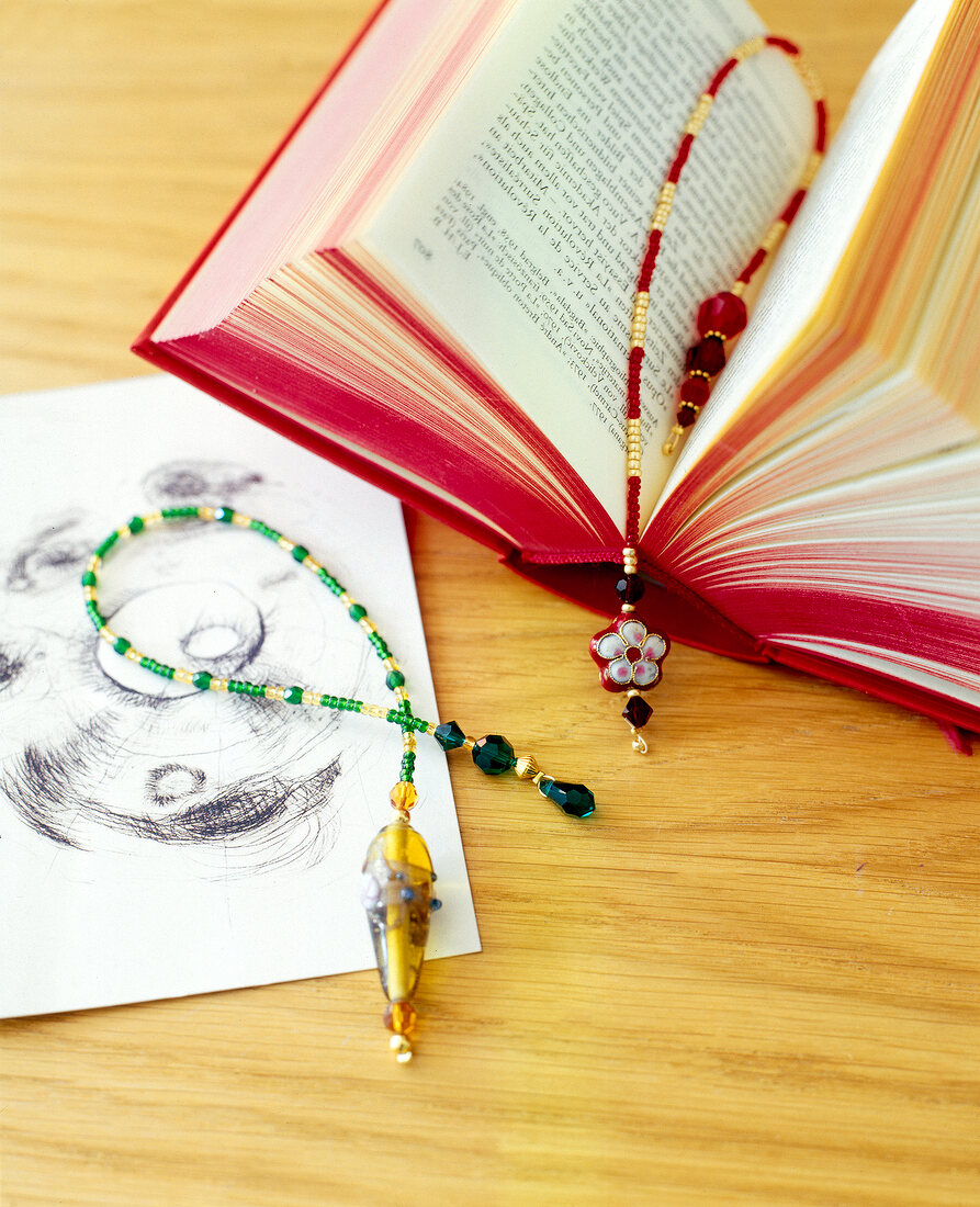 Book with beads bookmark on wooden surface